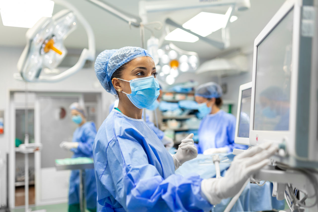 Nurse in a surgical suite checking a monitor.