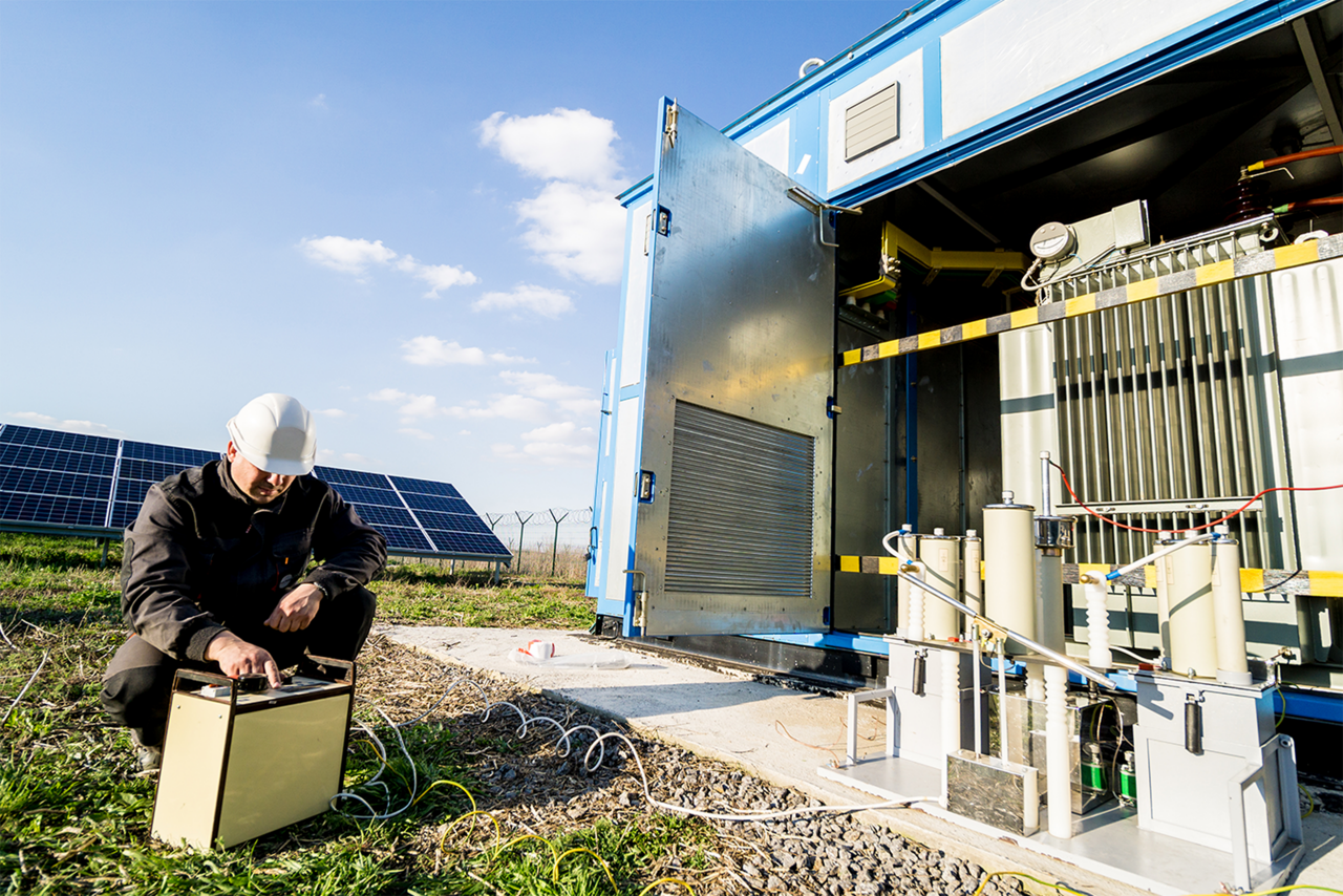 A technician maintains a battery energy storage system.