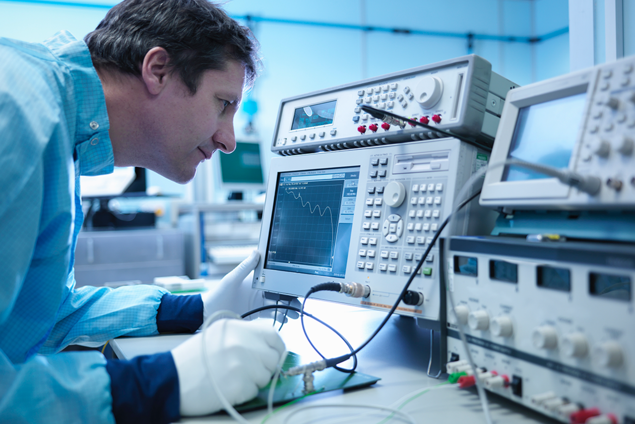 RF test and measurement technician checking electronics in clean room.
