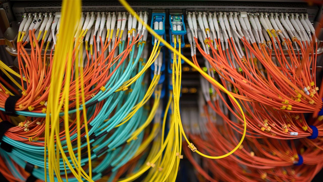 A dense array of colored fiber optic connectors within a data center infrastructure.  