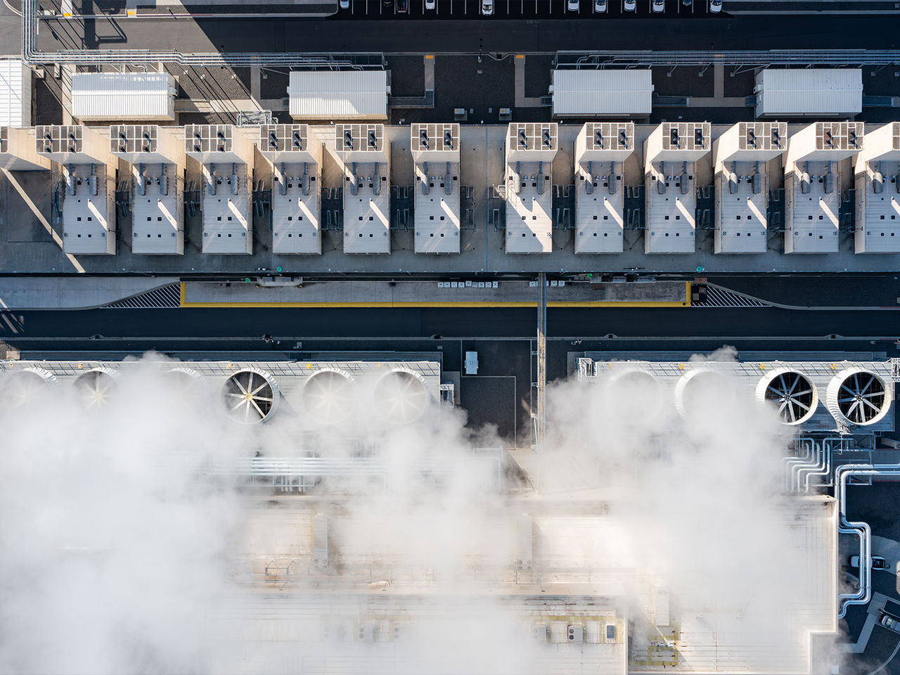 Aerial drone view of a hyperscale data center featuring rows of industrial cooling fans and evaporative cooling infrastructure.