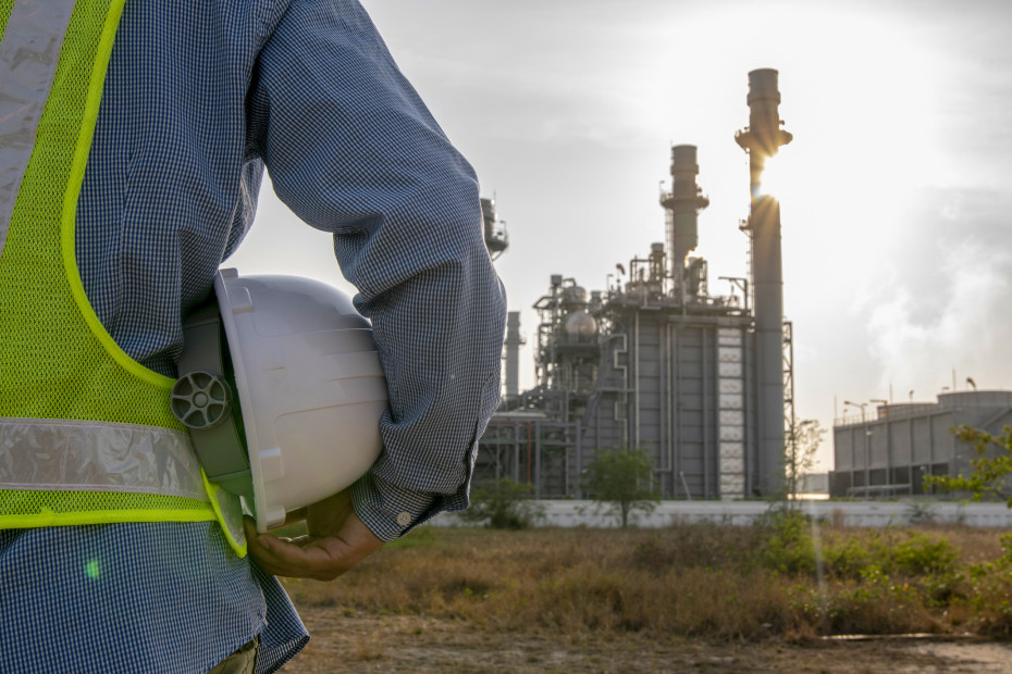 Industrial engineer outside an oil refinery site.