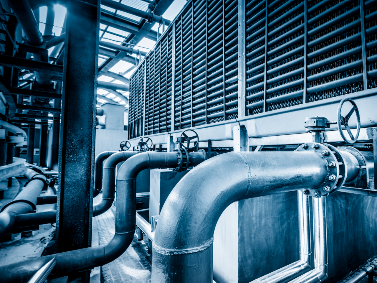 Large-scale industrial HVAC system with visible pipes and valves. 